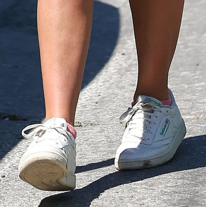 Addison Rae pairs her athleisure outfit with Reebok Club C Vintage sneakers, complete with soft pink socks and a worn-in retro finish that nods to the brand&rsquo;s classic tennis roots