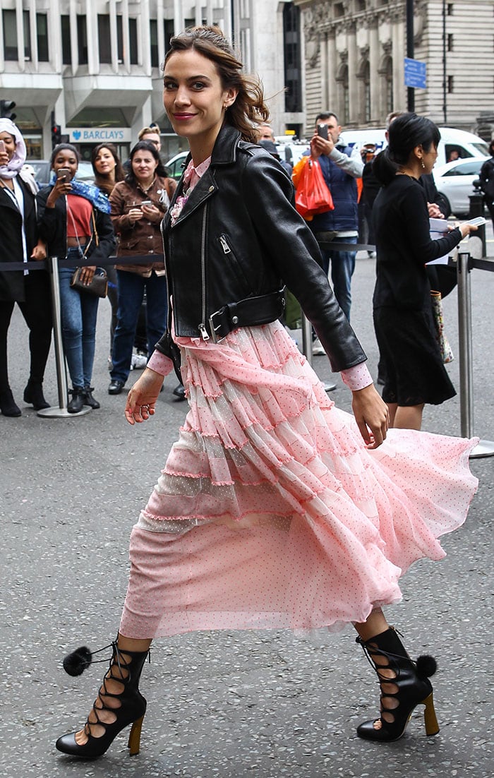 Alexa Chung strikes the perfect balance of edgy and romantic in a frilly pink Gucci dress styled with a cropped leather biker jacket and lace-up &ldquo;Heloise&rdquo; boots