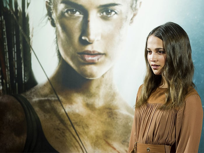 Vikander poses in front of her fierce Lara Croft poster backdrop, echoing the film&rsquo;s adventurous tone