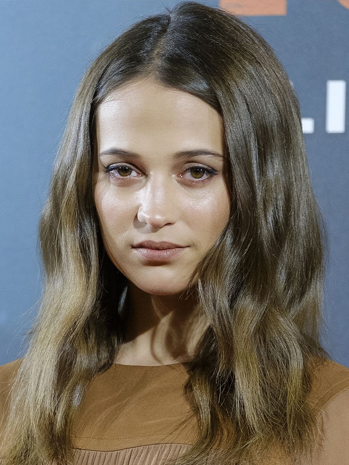 Alicia Vikander keeps her beauty look minimal with loose waves and natural makeup at the Madrid Tomb Raider photocall