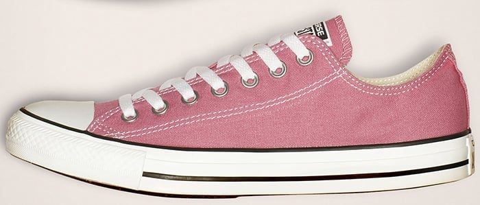 Authentic pink Converse Chuck Taylor All Star low-top featuring straight, solid paint along the rubber piping and classic white midsole