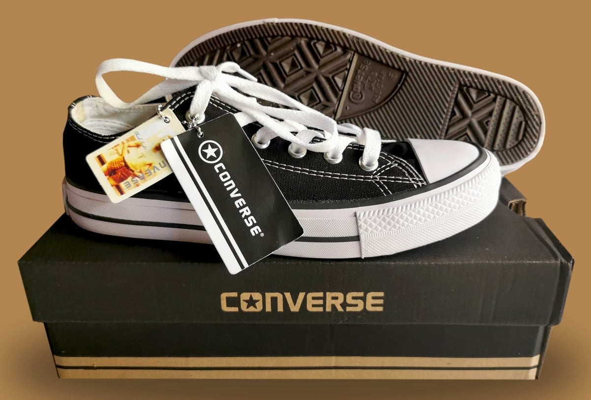 Authentic black Converse Chuck Taylor All Star low-top sneakers displayed with retail packaging featuring the brand&rsquo;s iconic logo