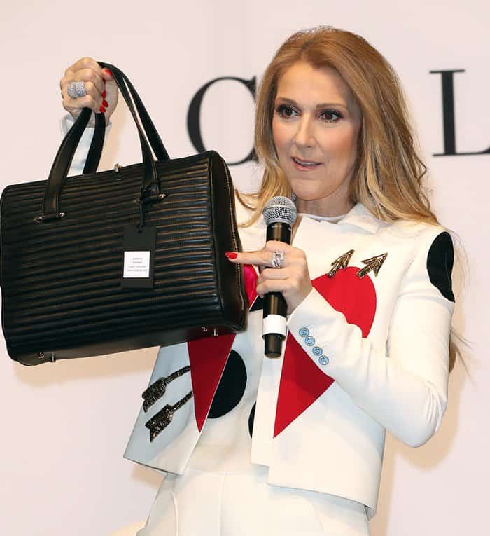 C&eacute;line Dion proudly showcases one of her handbags from the new collection at the Project Women&rsquo;s trade fair