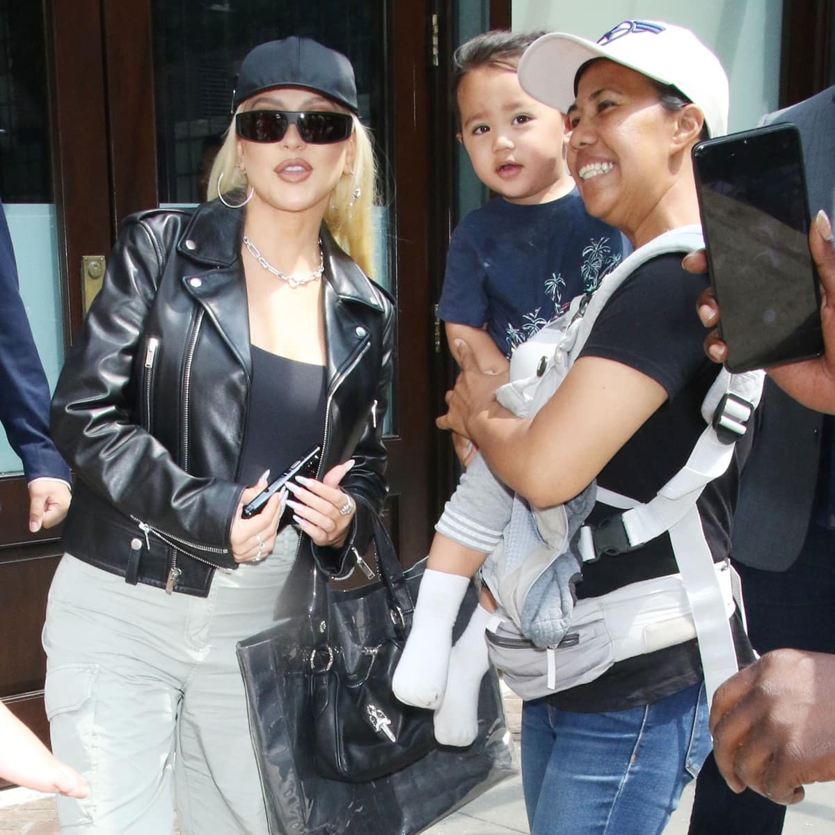 Christina Aguilera keeps it cool in a black leather moto jacket, fitted tank top, cargo pants, and oversized sunglasses while greeting fans in New York City