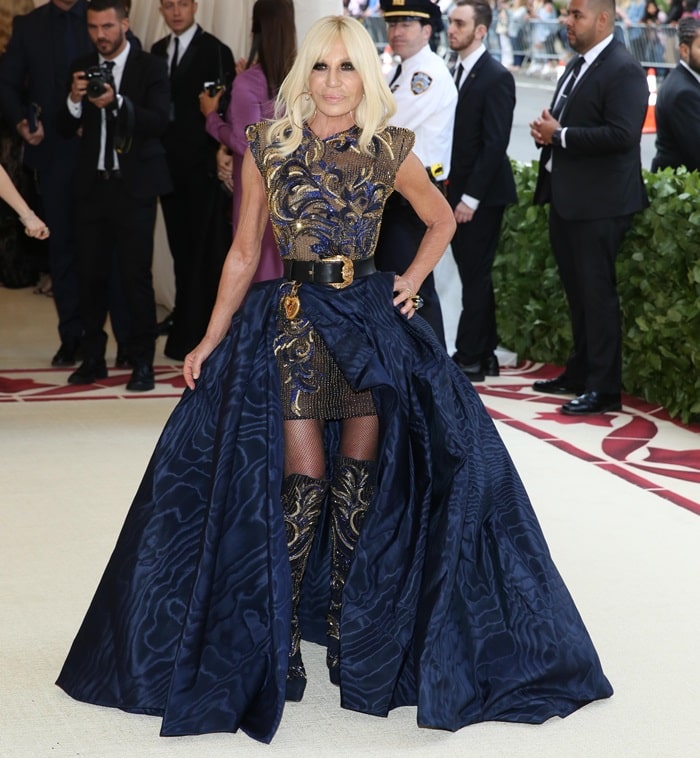 Donatella Versace&nbsp;in an embroidered mini dress styled with&nbsp;matching knee boots and a black belt