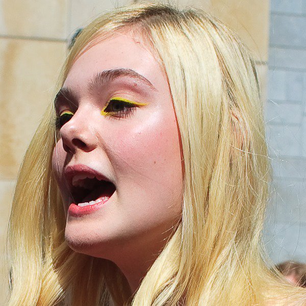 A closer look at Elle Fanning&rsquo;s playful beauty choice, featuring bright yellow eyeliner that echoes the youthful energy of her coral lace ensemble
