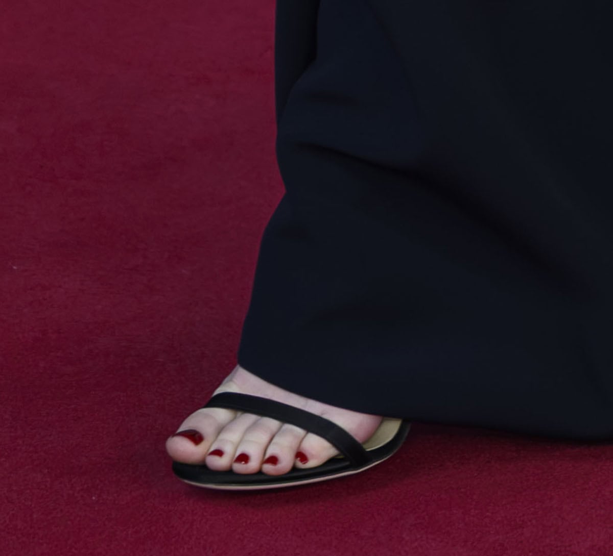 Emma Stone keeps her footwear understated, choosing the red-carpet favorite Jimmy Choo &ldquo;Minny&rdquo; sandals in black