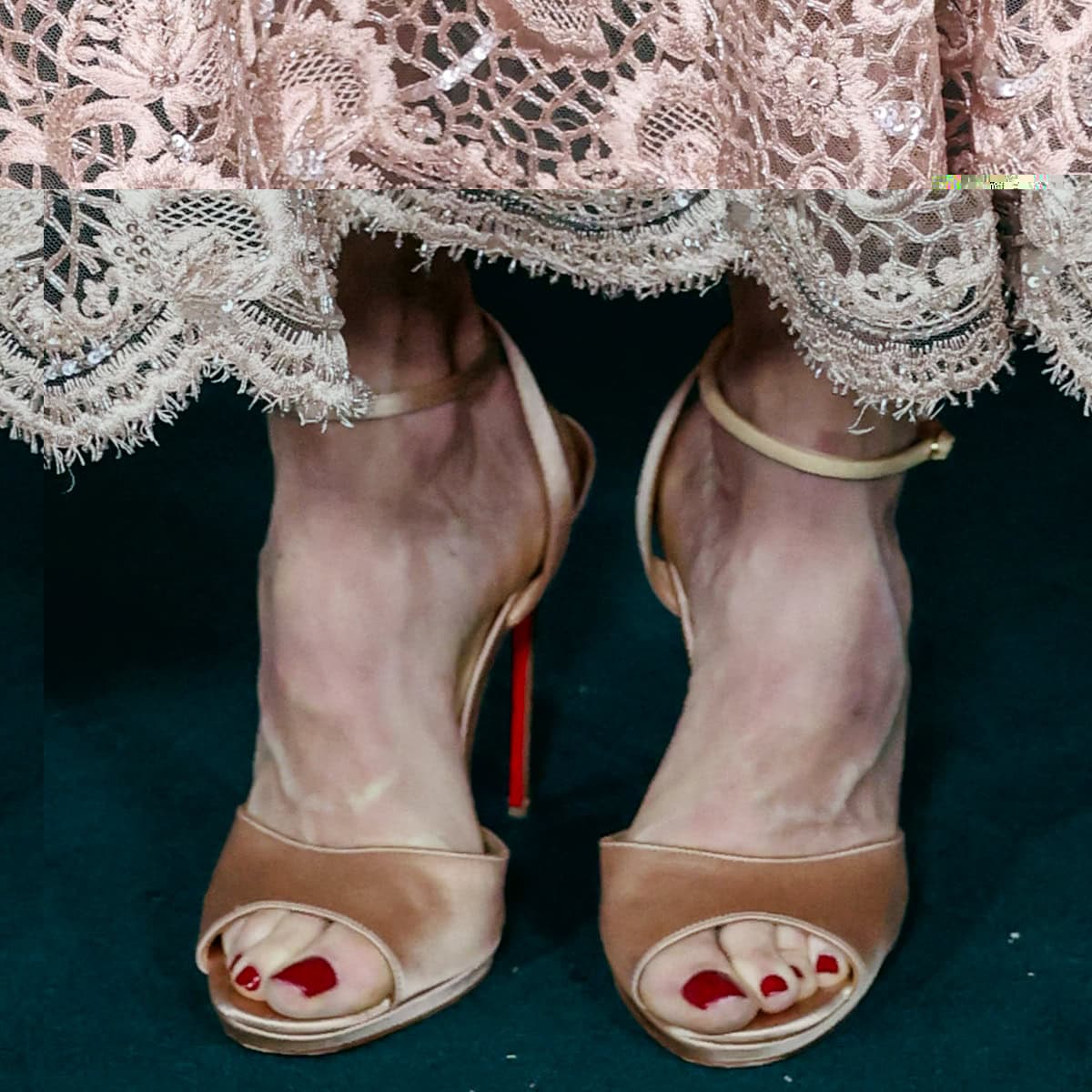 Julie Bowen shows off a glossy red pedicure in nude satin peep-toe ankle-strap heels by Christian Louboutin, revealing the brand&rsquo;s signature red soles and her elegant, narrow foot shape&mdash;likely around a US women&rsquo;s shoe size 7.5, which she reportedly wears