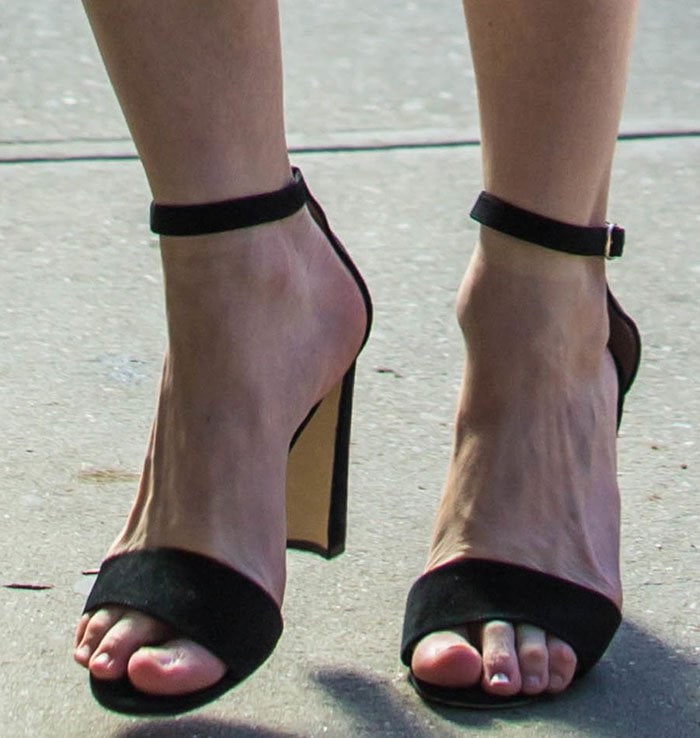Kirsten Dunst&rsquo;s feet take center stage in black Manolo Blahnik &ldquo;Lauratopri&rdquo; sandals, where slim ankle straps and a softly squared toe frame her pedicure while the sculptural half-moon block heel adds a modern, architectural finish