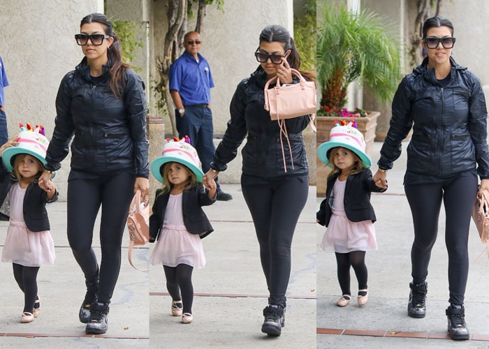Kourtney Kardashian&rsquo;s daughter Penelope looks adorable in a pale pink ballet dress layered with a black blazer, black tights, and blush ballet flats, finishing the look with a playful birthday cake&ndash;themed hat