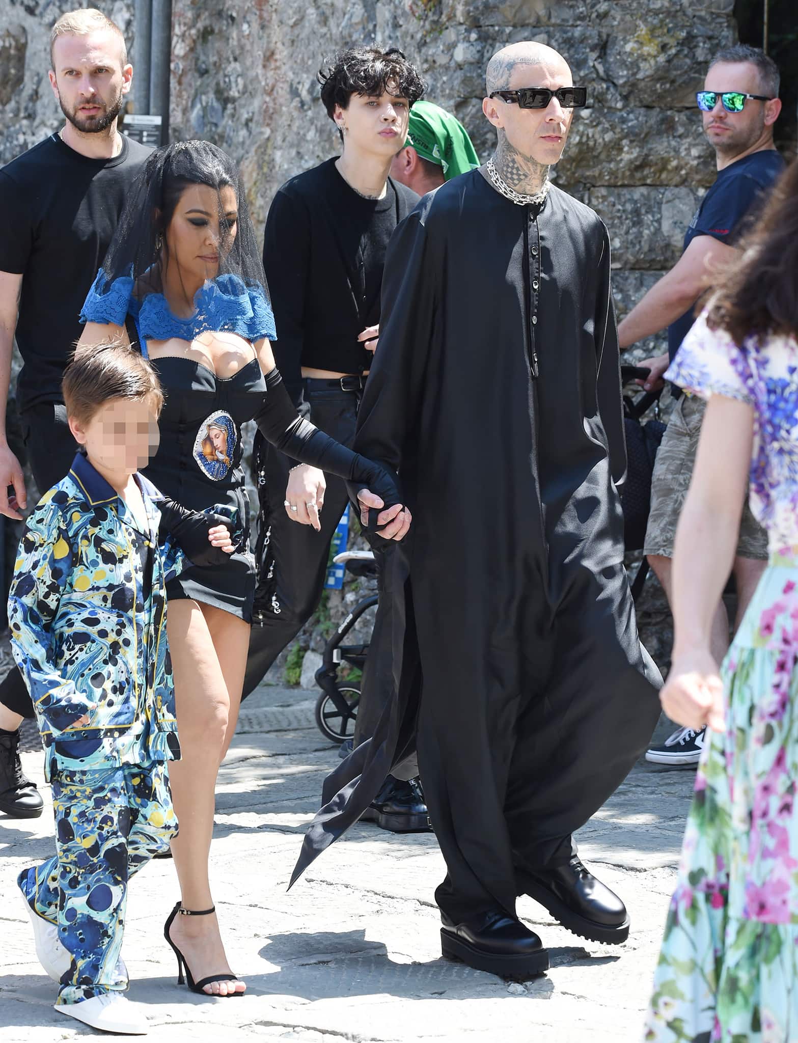 Kourtney Kardashian steps out in a vintage Dolce & Gabbana Virgin Mary mini dress paired with sheer gloves and black ankle-strap stiletto sandals as she joins Travis Barker en route to their pre-wedding lunch at the Abbey of San Fruttuoso in Portofino on May 21, 2022