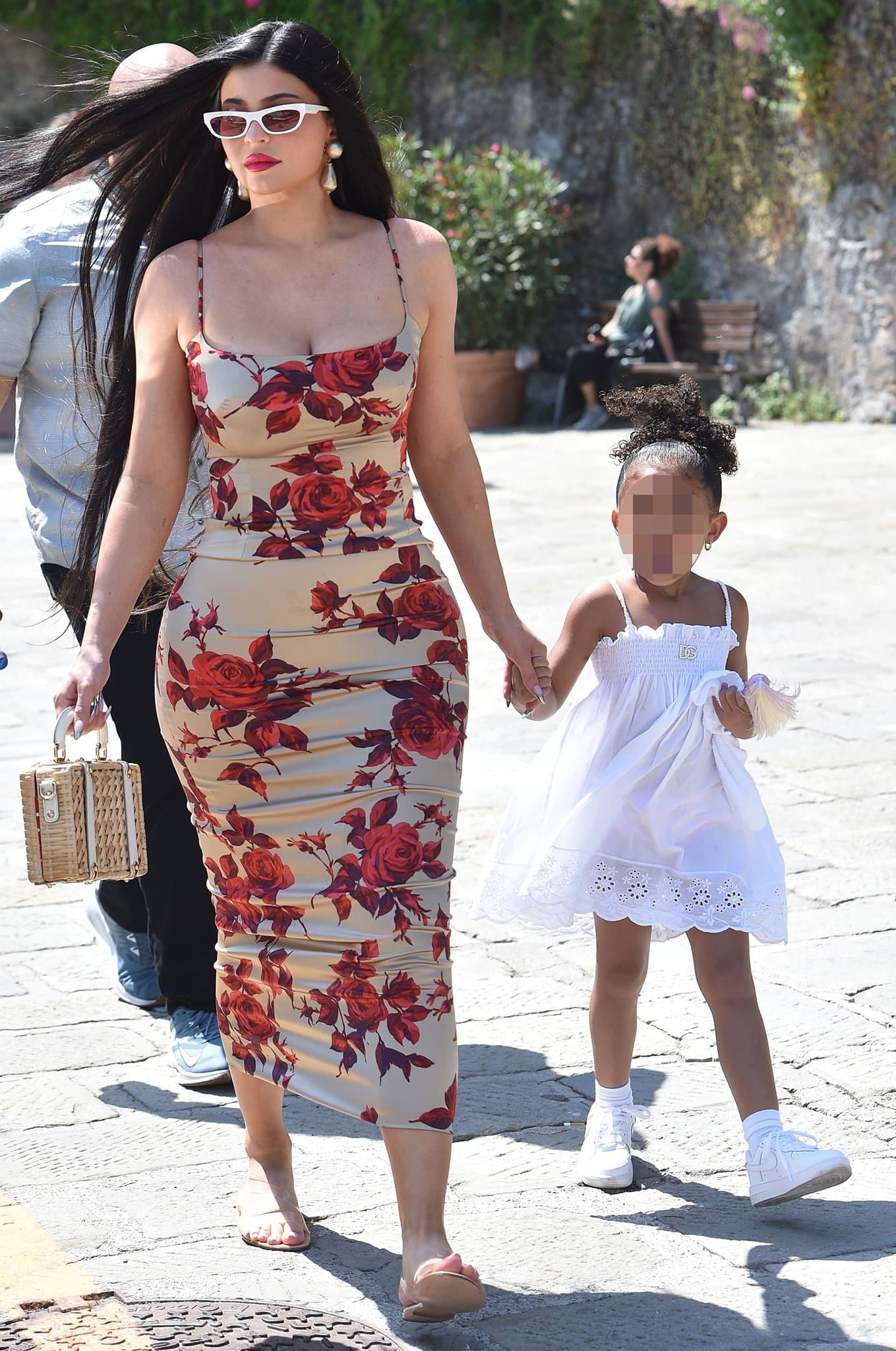 Kylie Jenner strolls through Portofino in a figure-hugging &rsquo;90s Dolce & Gabbana rose-print dress styled with white cat-eye sunglasses and transparent Gianvito Rossi &ldquo;Metropolis&rdquo; Plexi-strap sandals while holding hands with daughter Stormi