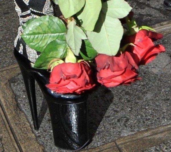 A close-up reveals Gaga&rsquo;s ultra-high black patent platform heels peeking out beneath the embellished Versace jumpsuit