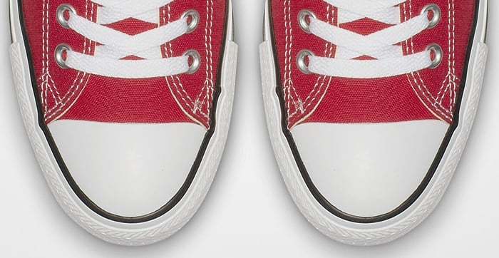 Authentic Converse Chuck Taylor All Star sneakers featuring signature solid white rubber toe caps and clean black piping