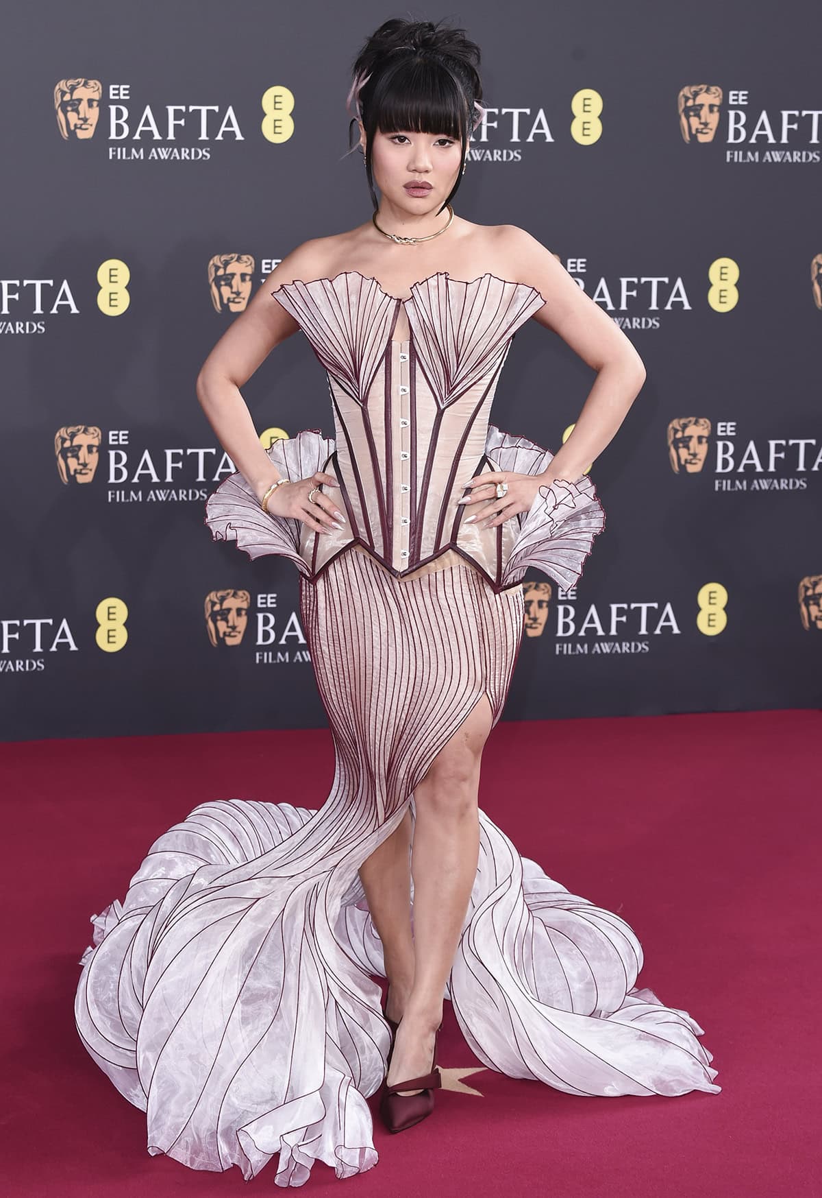 Rei Ami teams her understated pumps with a mermaid-inspired Jasmin Erbas Couture dress featuring a corset bodice with a seashell-like bust, waist, and a whimsical mermaid tail skirt