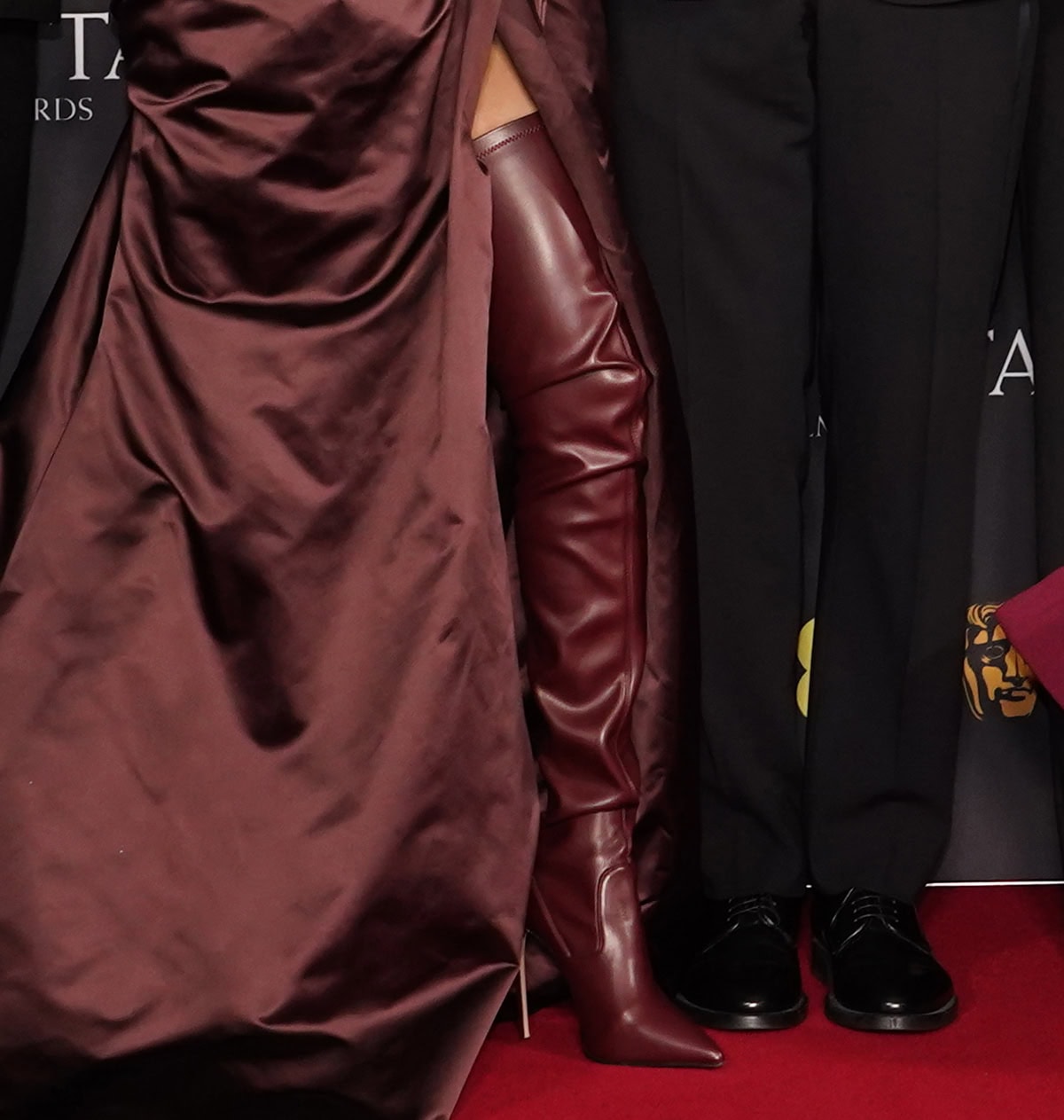 Teyana Taylor makes a strong entrance in Le Silla &ldquo;Eva&rdquo; thigh-high boots in cherry red vegan leather with slouchy shafts, pointed toes, and stiletto heels