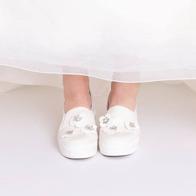 Bead- and crystal-accented 3D floral appliqu&eacute;s detail the toe of a charming platform sneaker
