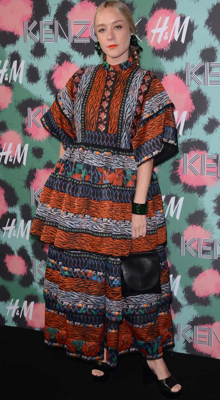 Chlo&euml; Sevigny brings her signature edgy elegance to the Kenzo x H&M fashion show, styling the bold patterned maxi dress with sleek braids, statement accessories, and black platform heels