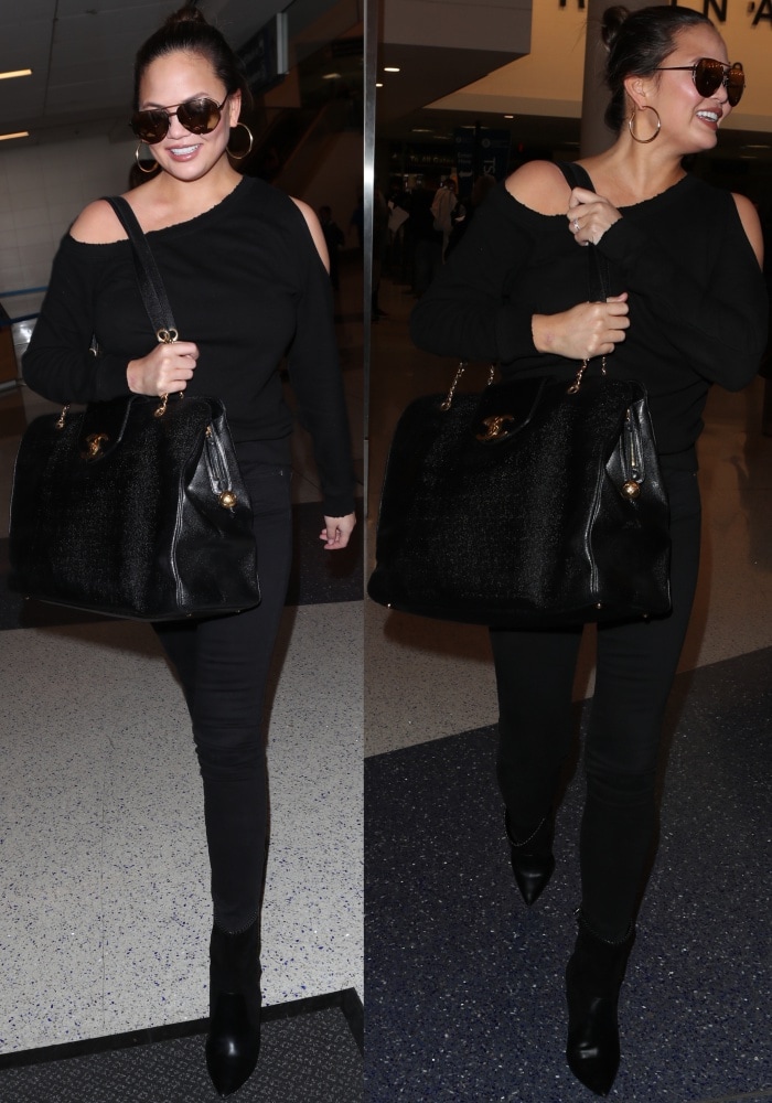 Chrissy Teigen sharpens her all-black airport look with Saint Laurent &ldquo;Niki&rdquo; boots, pairing the pointed-toe silhouette with an RTA Willow sweatshirt, J Brand skinny jeans, and a classic Chanel Supermodel XL bag for effortless off-duty polish