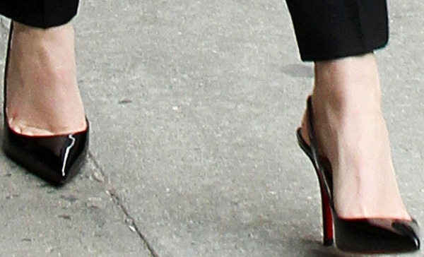 Emma Watson steps out in sleek Christian Louboutin Apostrophy Sling pumps, featuring glossy black patent leather and the designer&rsquo;s signature red soles
