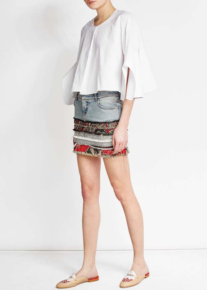 The model is wearing Malone Souliers x Natalia Vodianova &ldquo;Neva&rdquo; leather slippers with linen stitching, a Delpozo top, and a Faith Connexion patchwork denim skirt